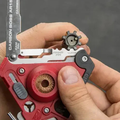 Czyszczenie zewnętrznej powierzchni zamka AR-15 przy użyciu zintegrowanego otworu ze szczotką z brązu fosforowego w multitoolu Carbon Boss.